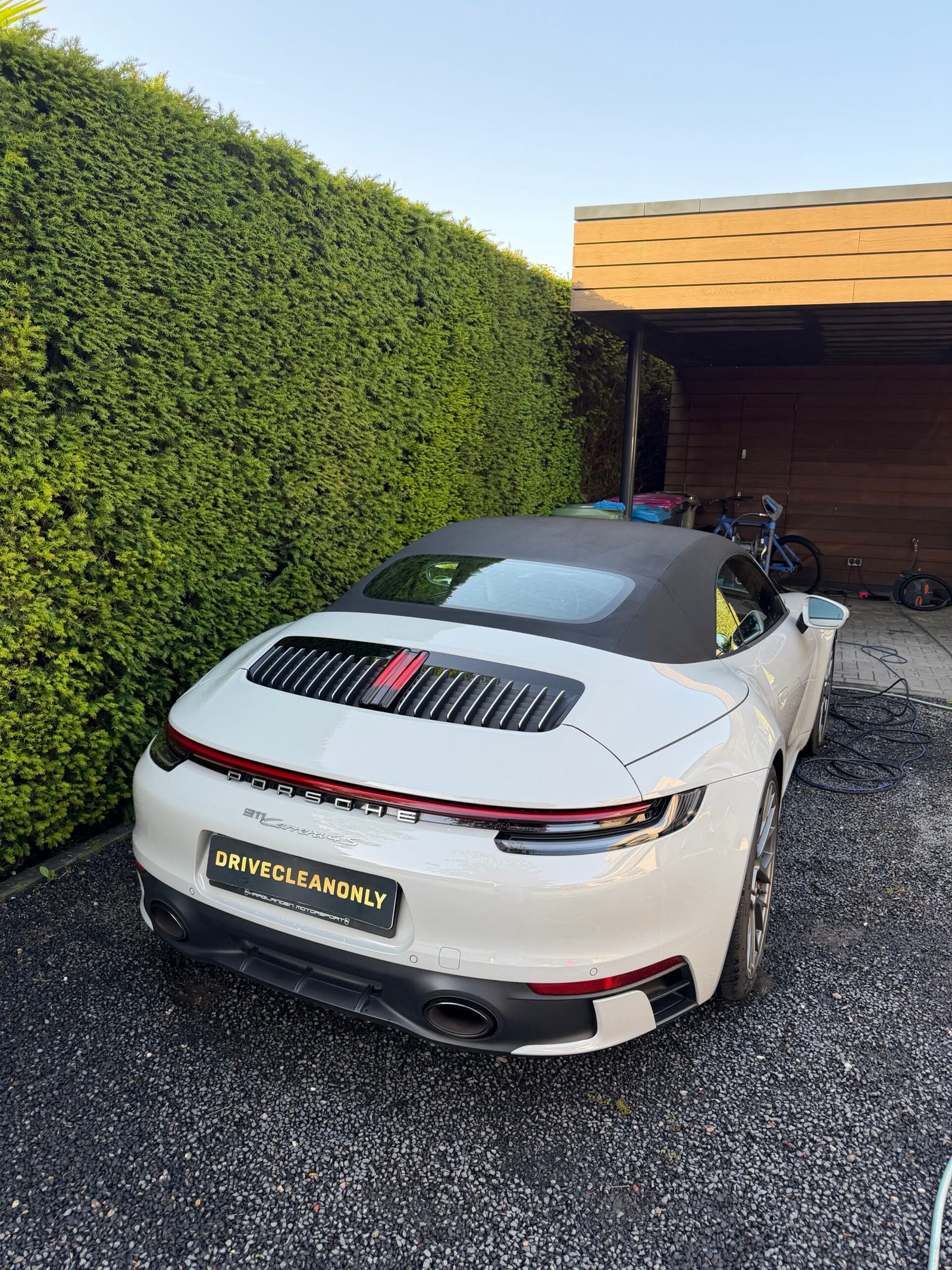 Witte Porsche 911 cabriolet met DriveCleanOnly-kentekenplaat na een detailbehandeling